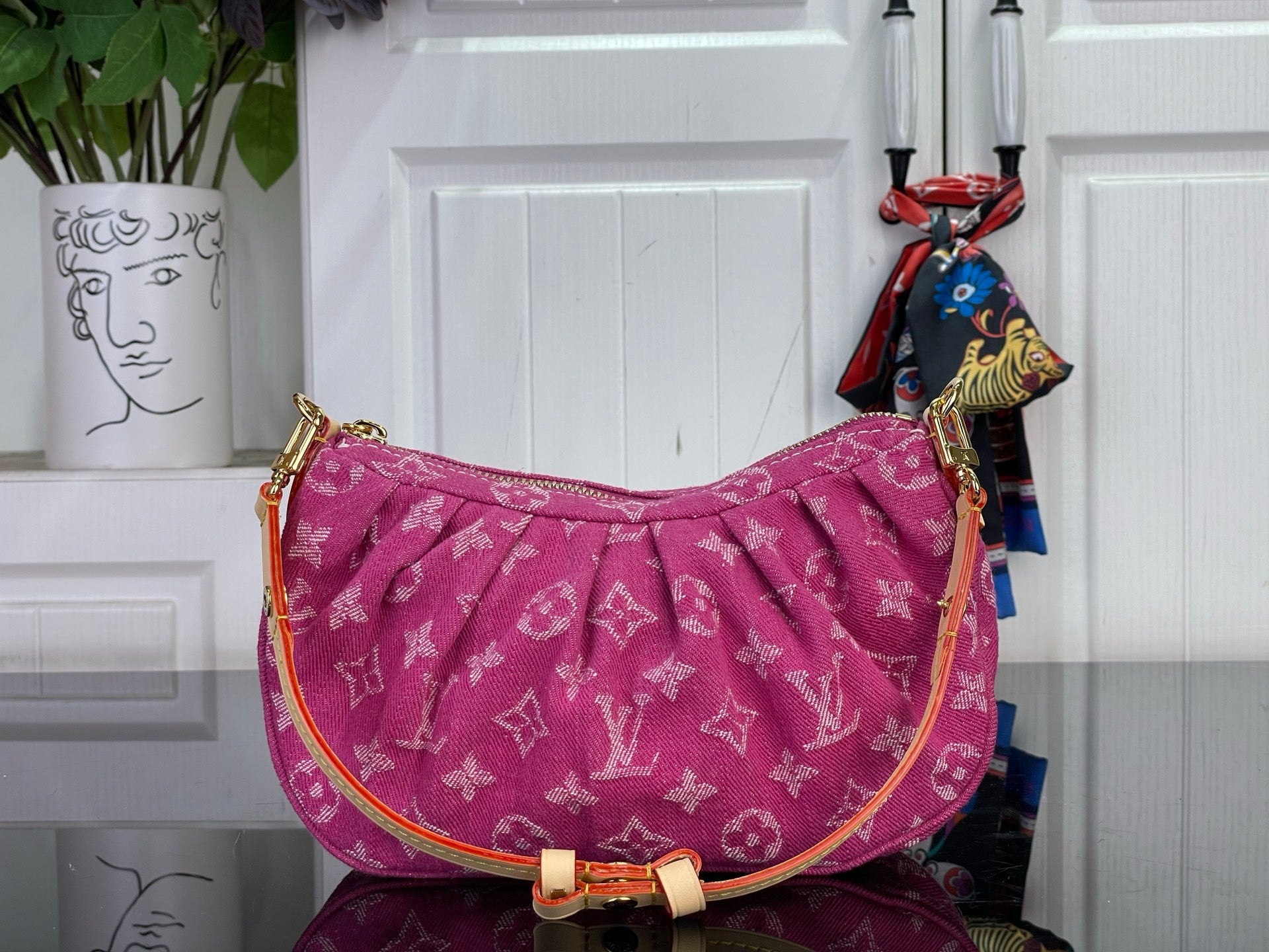 Louis Vuitton pink monogram hobo bag with curved top and gold-tone shoulder strap.