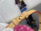 Louis Vuitton leather shoulder strap with gold buckle and red accent on pink monogram bag.