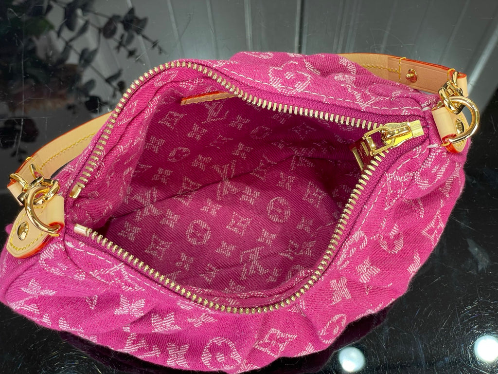 Louis Vuitton pink monogram bag interior with zippered top and gold zipper pull tabs.