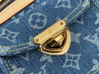 Gold front clasp on blue monogram denim flap pocket with yellow stitching