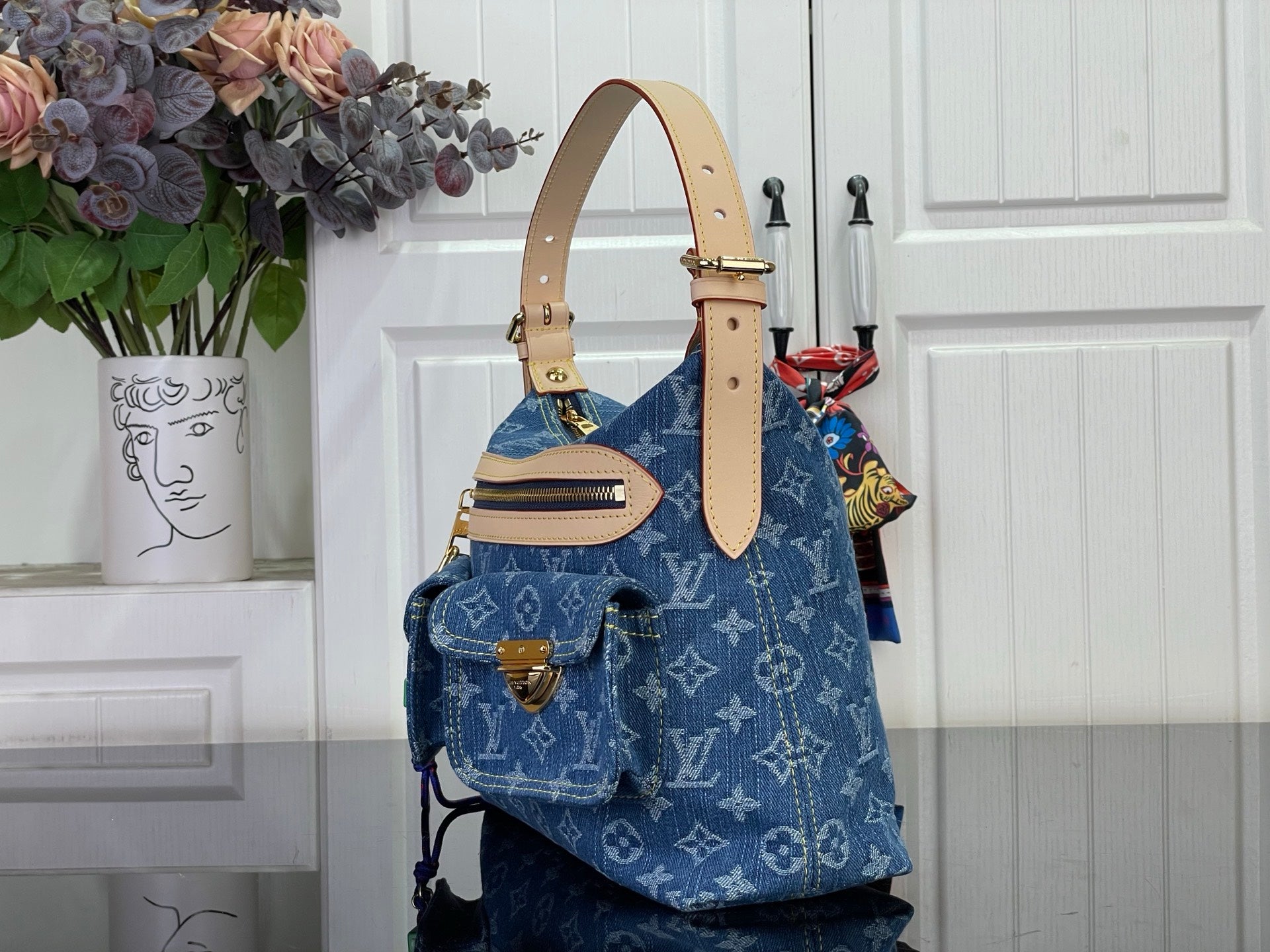 Blue monogram denim handbag with beige shoulder strap and gold hardware