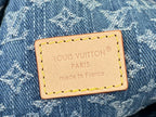 Tan leather brand patch on blue monogram denim bag with stitched border