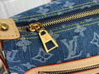 Gold zipper pull and tab on blue monogram denim with yellow stitching