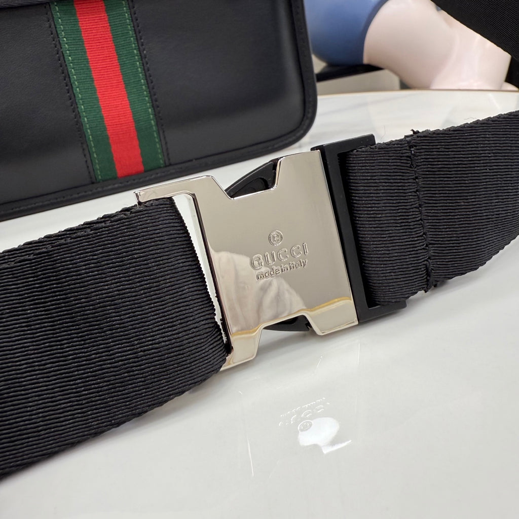 Gucci strap hardware with silver buckle and engraved logo on dark woven webbing
