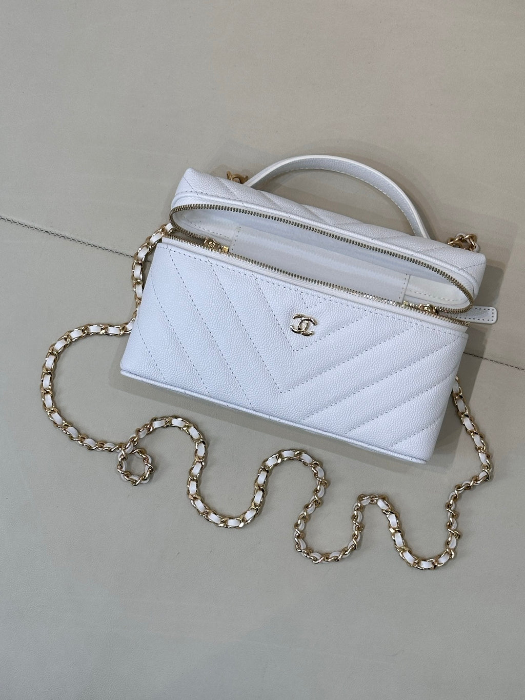 Light blue quilted mini handbag with gold chain strap and top handle