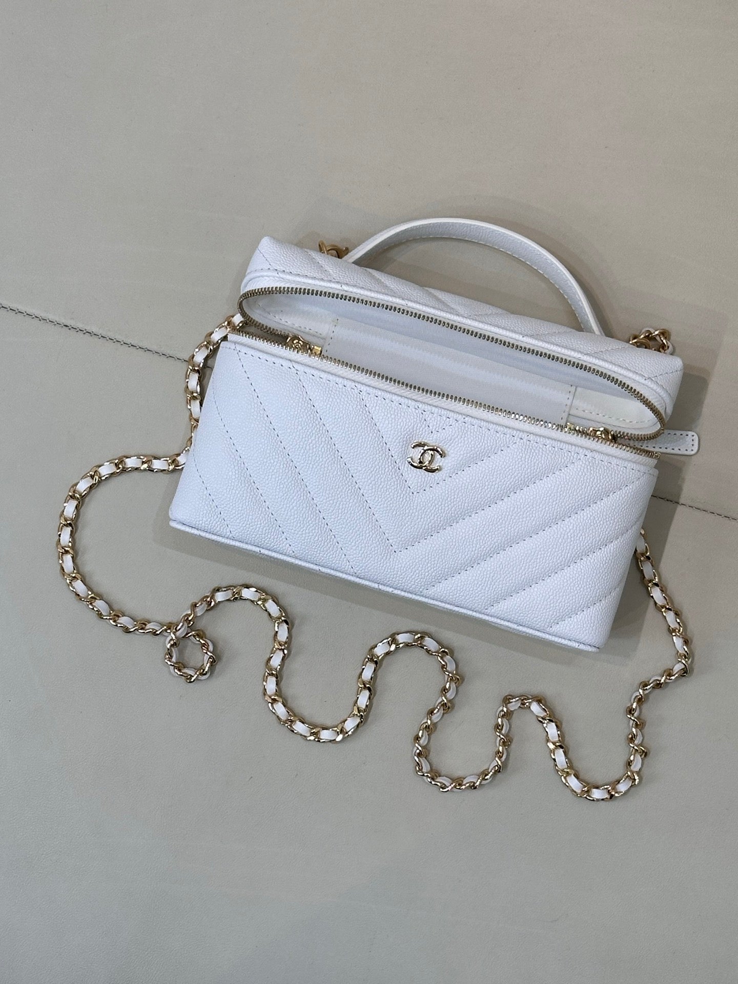 Light blue quilted mini handbag with gold chain strap and top handle