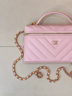 Pink quilted Chanel mini handbag with front zipper and gold chain shoulder strap