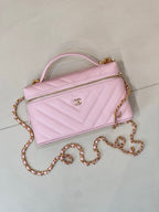 Pink quilted Chanel mini handbag with top handle, gold chain strap, front logo