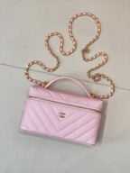 Pink quilted Chanel mini handbag with curved top handle and gold chain strap