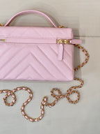 Close-up of pink quilted Chanel mini handbag with gold clasp and chain strap
