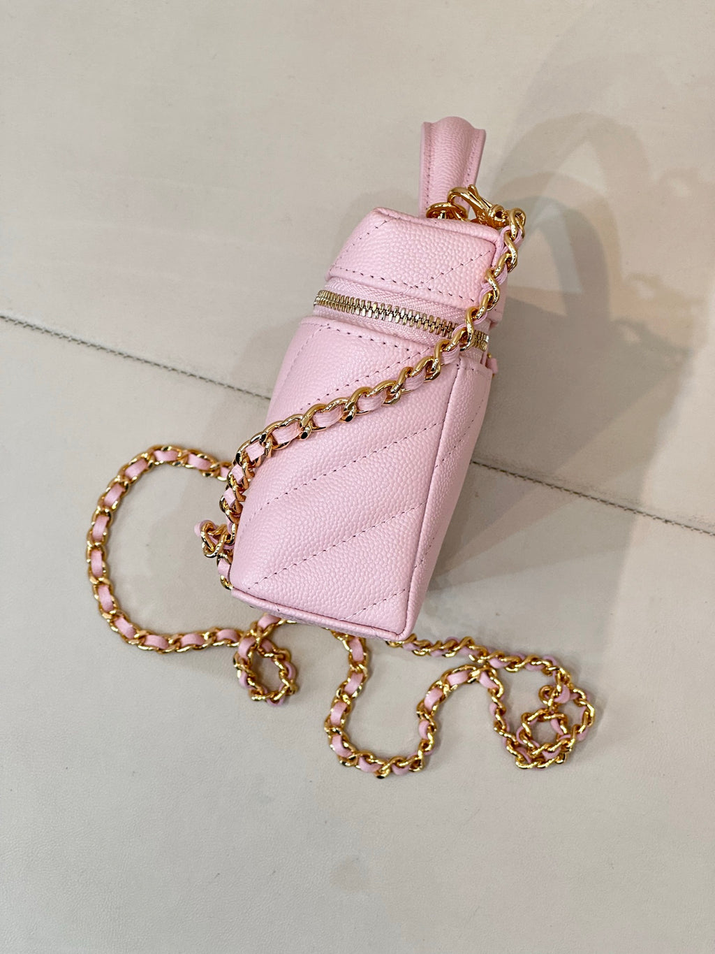 Pink mini Chanel handbag with flap-like top, gold-tone hardware and chain strap
