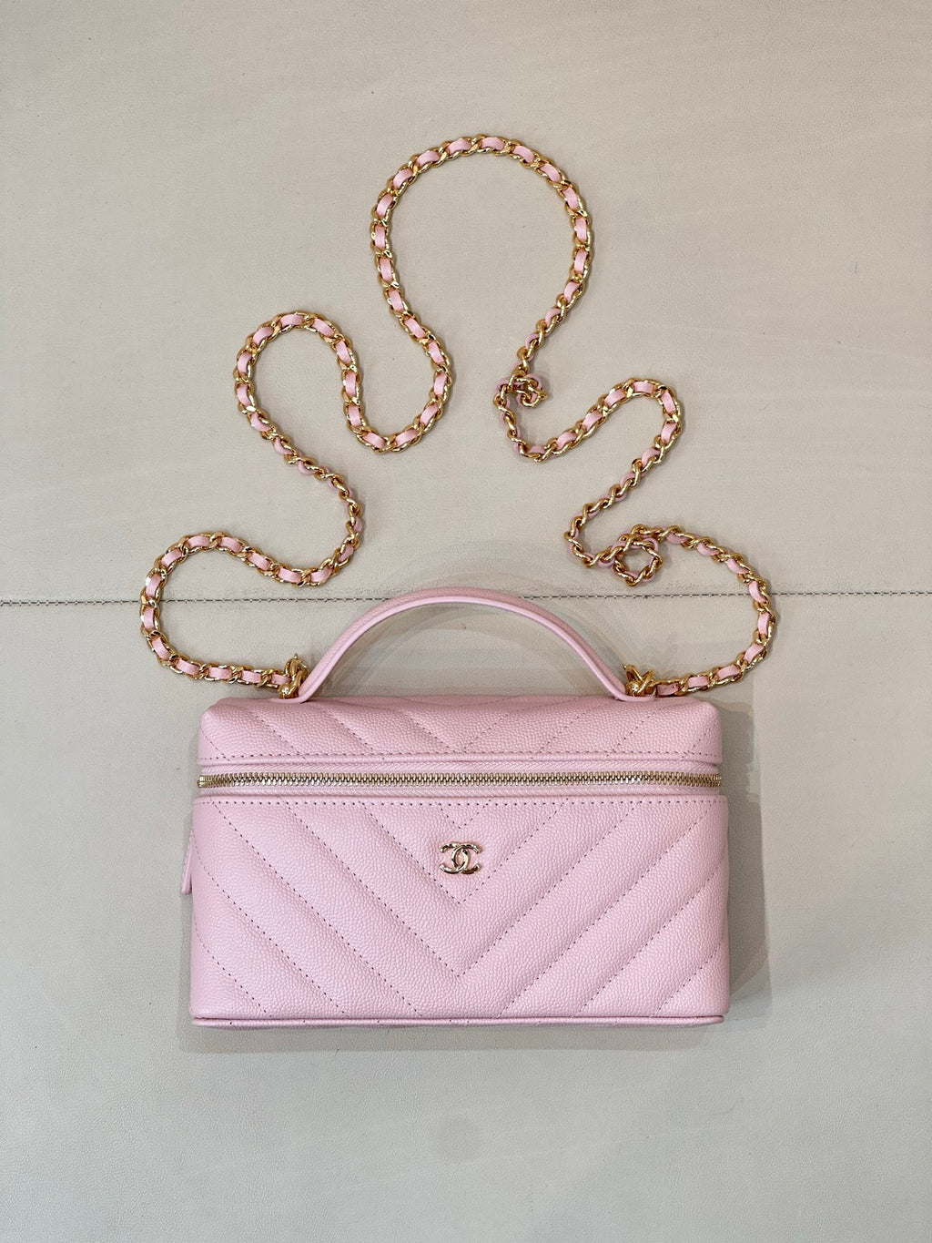 Pink quilted Chanel mini handbag with top handle and gold-tone chain strap