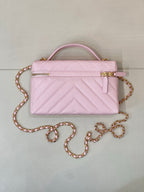 Pink quilted Chanel mini handbag with top handle and gold chain crossbody strap