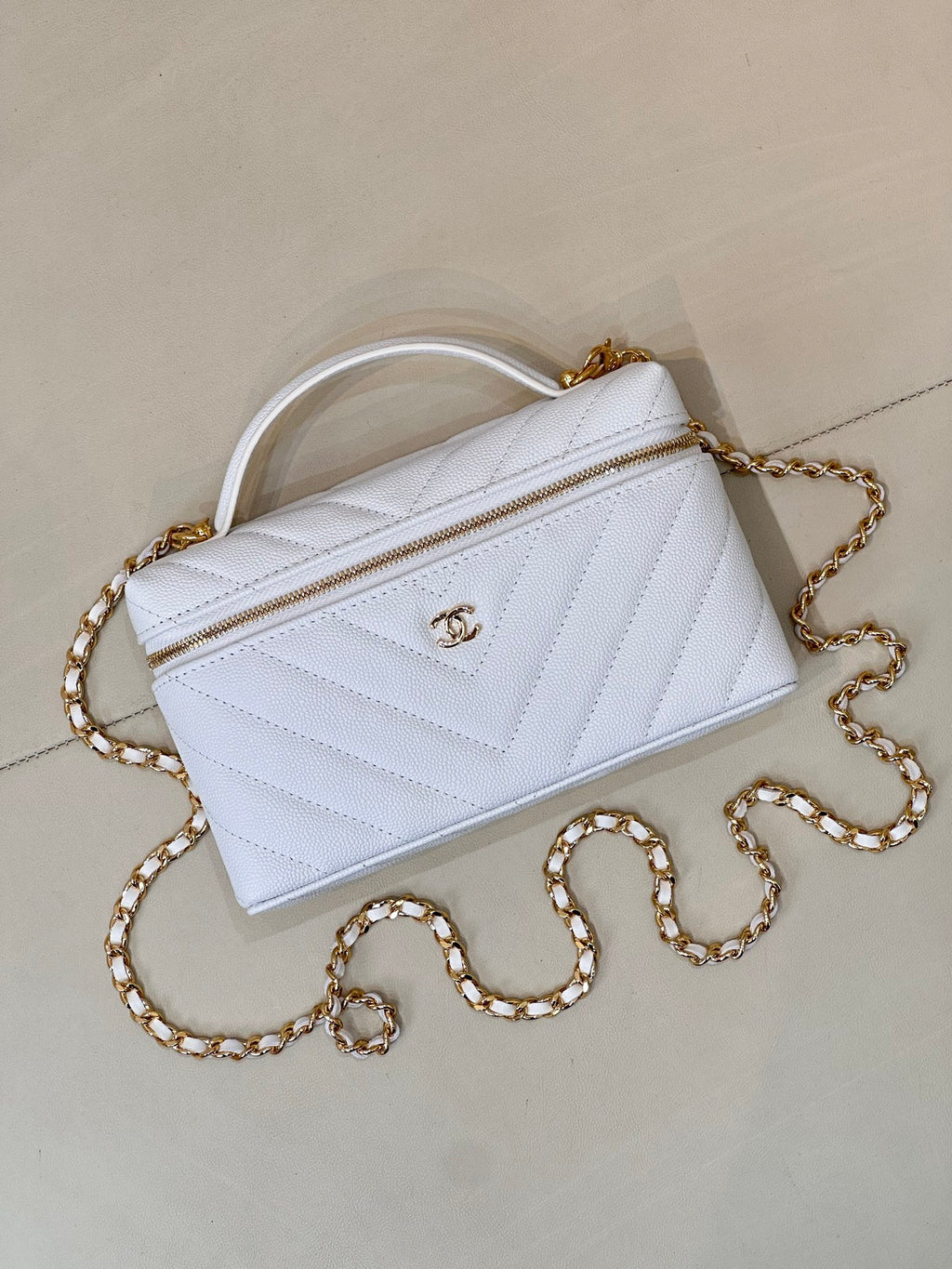 Light blue quilted mini handbag with front zip pocket, gold chain, and top handle