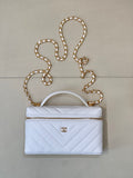 Quilted light blue mini handbag with gold chain strap, top handle, and zipper closure