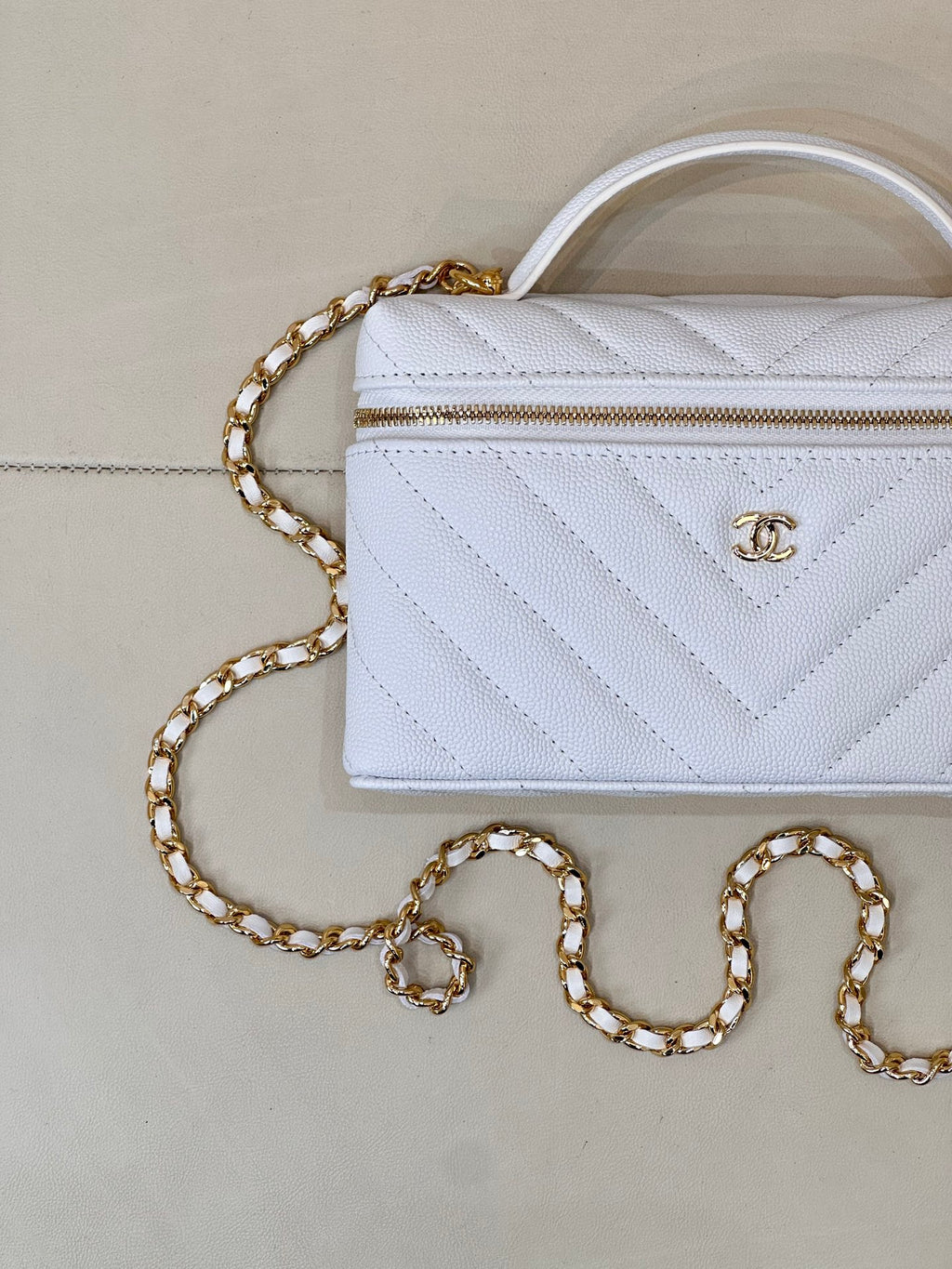 Quilted light blue mini handbag with gold chain, front emblem, and top handle