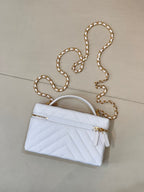 Quilted light blue mini handbag with gold chain strap and front zip closure