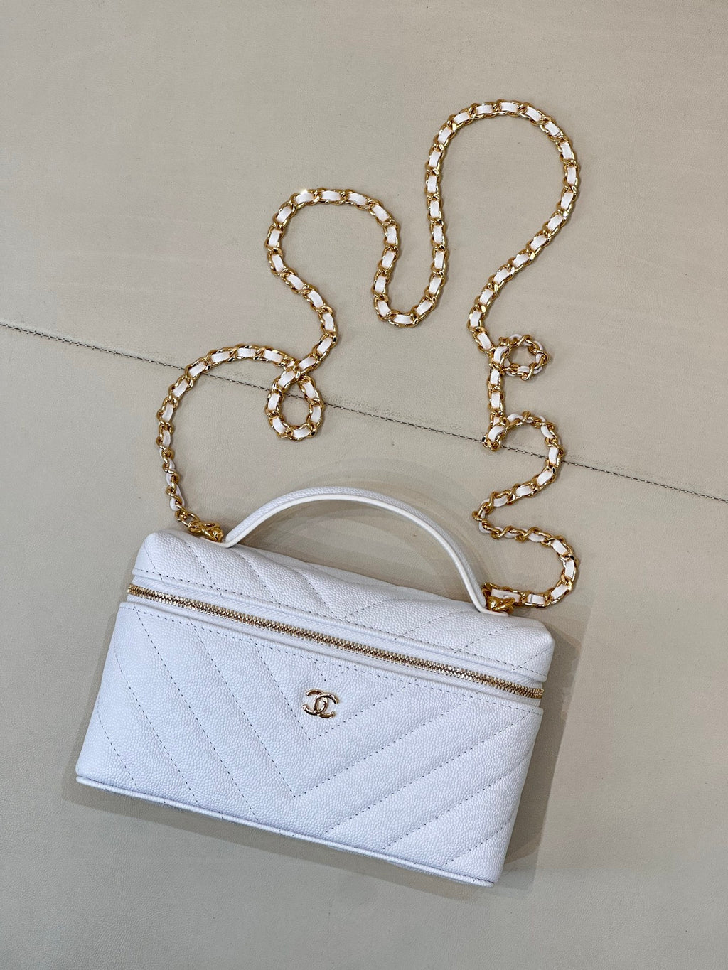 Light blue quilted mini handbag with gold chain strap and short top handle