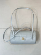 Light blue Chanel handbag with short handles, long strap, front gold logo emblem