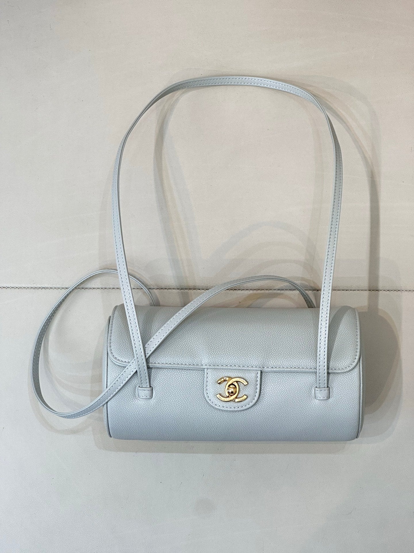Light blue Chanel handbag with short handles, long strap, front gold logo emblem
