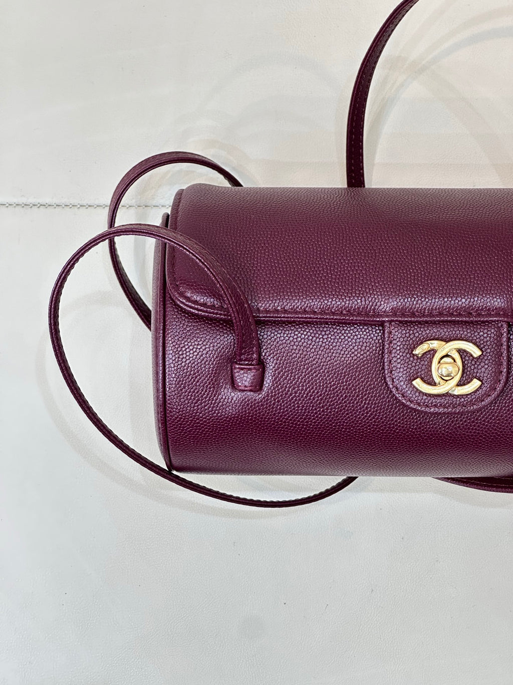 Burgundy leather mini shoulder bag close-up of flap, gold CC emblem on front