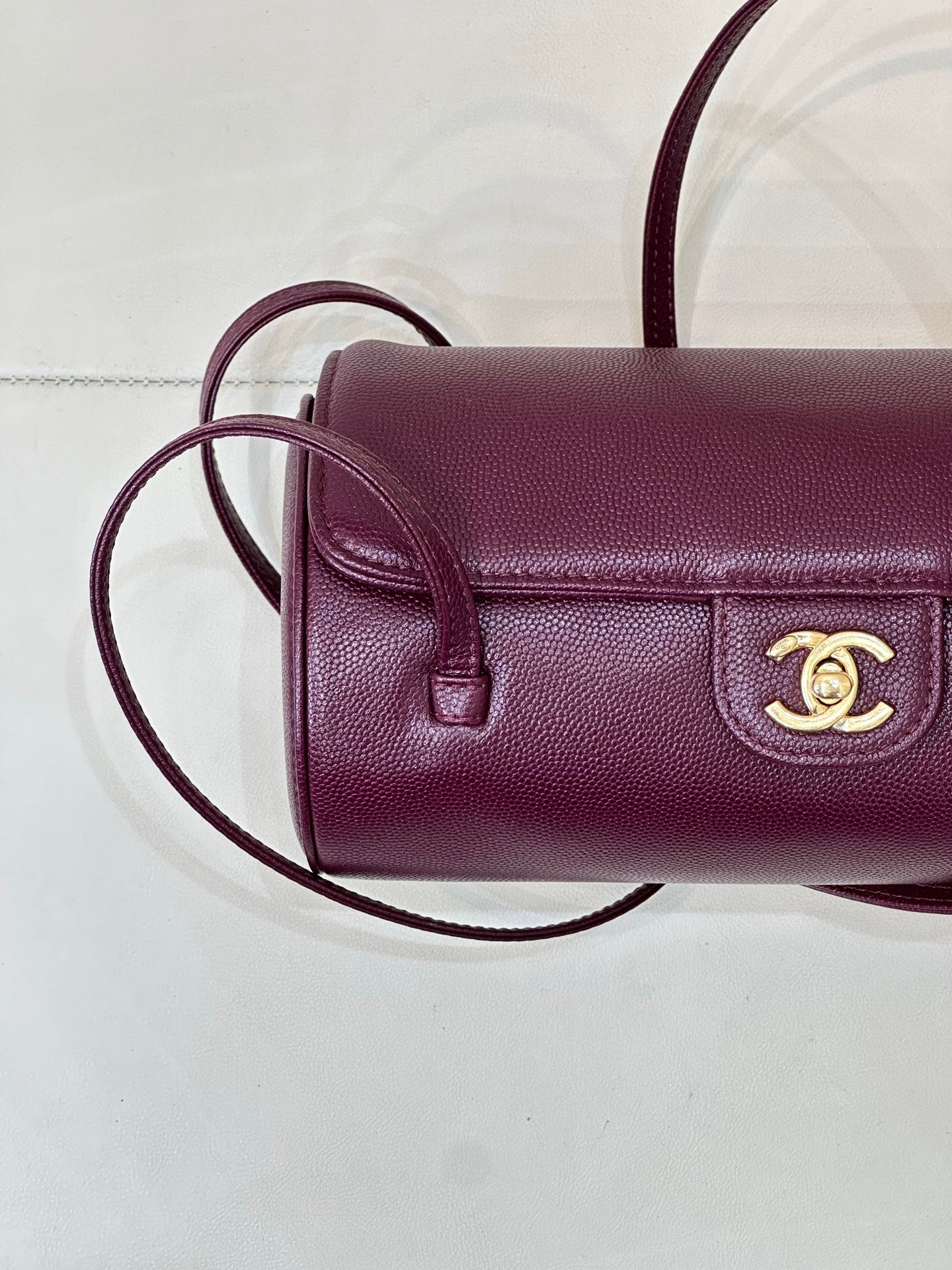 Burgundy leather mini shoulder bag close-up of flap, gold CC emblem on front