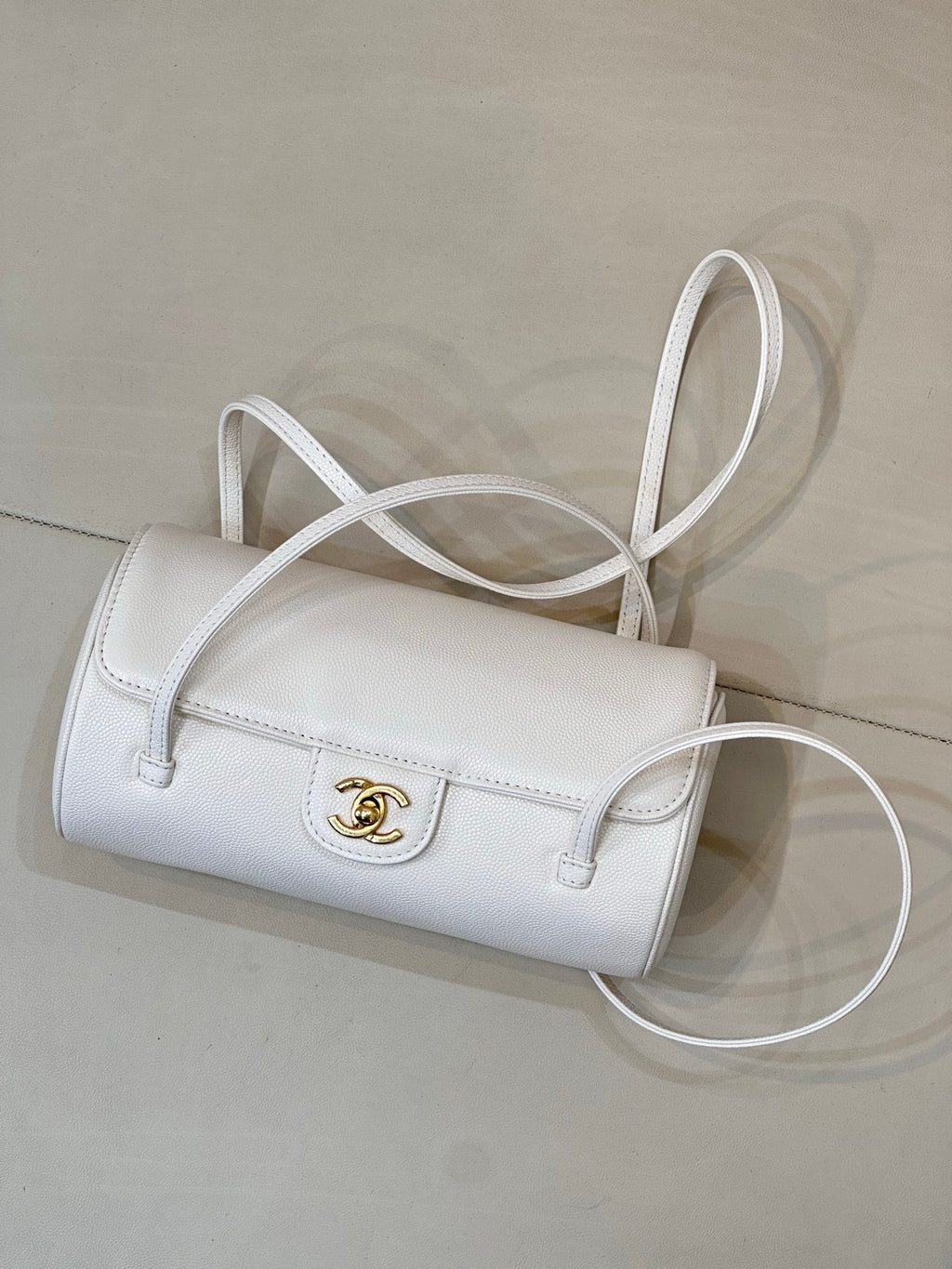 Chanel white leather handbag with flap, gold CC turn-lock, and shoulder strap.