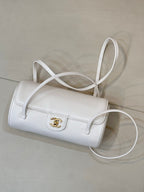 Chanel white leather handbag with flap, gold CC turn-lock, and shoulder strap.