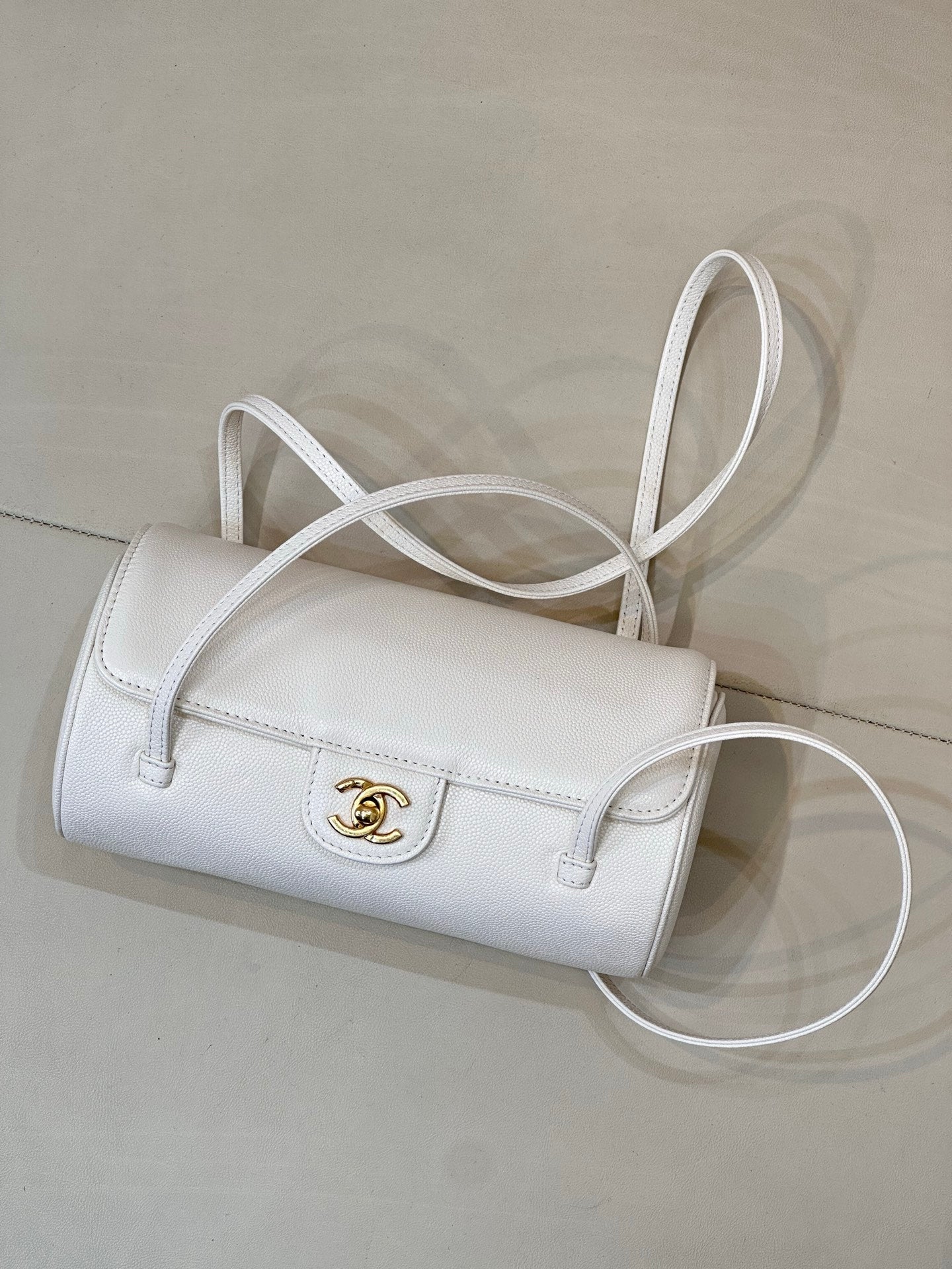 Chanel white leather handbag with flap, gold CC turn-lock, and shoulder strap.