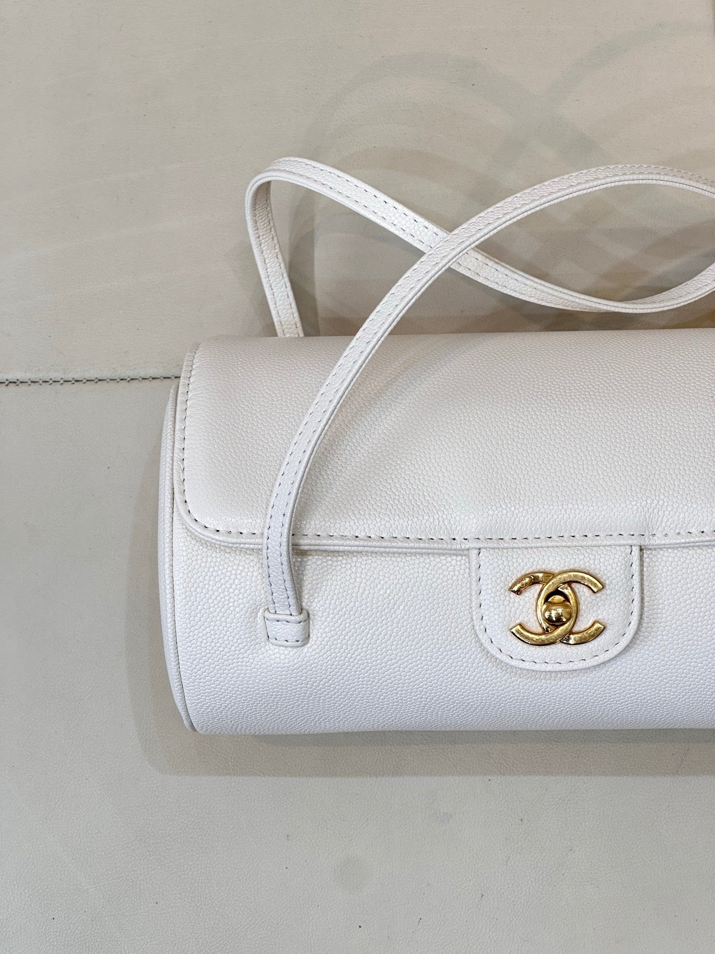 Chanel white leather handbag front view with gold CC logo and double-strap top.