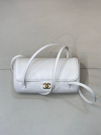 Chanel white leather mini handbag with flap, gold CC logo, and curved crossbody strap.
