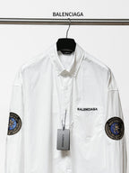 Balenciaga long-sleeve button-up shirt, white, front view with chest logo and sleeve patches.