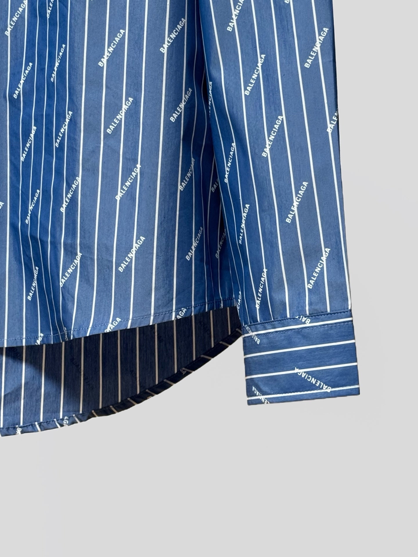 Blue button-up shirt with vertical pinstripe logo print and striped hem detailing