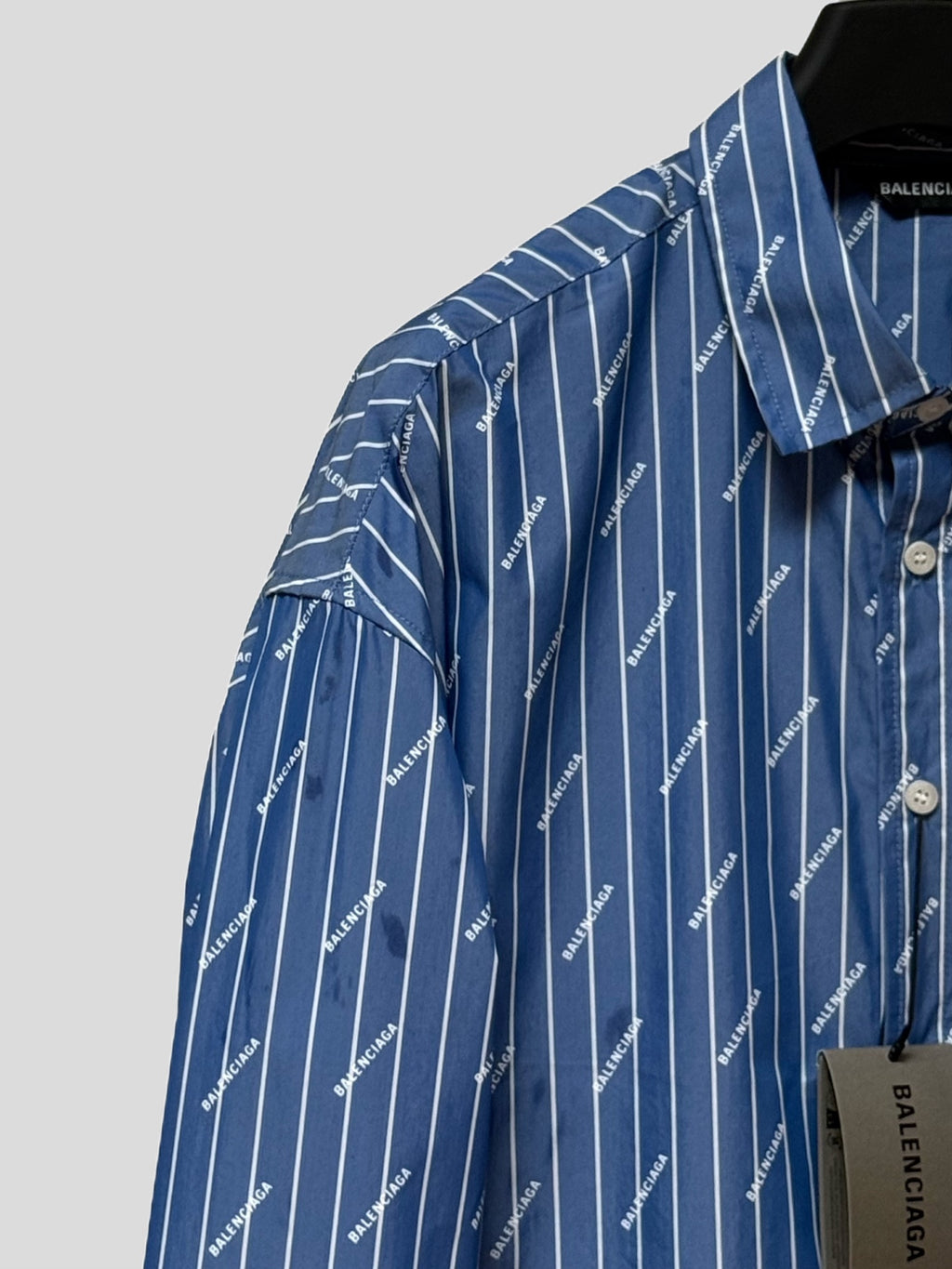 Blue button-up shirt with pointed collar and vertical pinstripe logo pattern