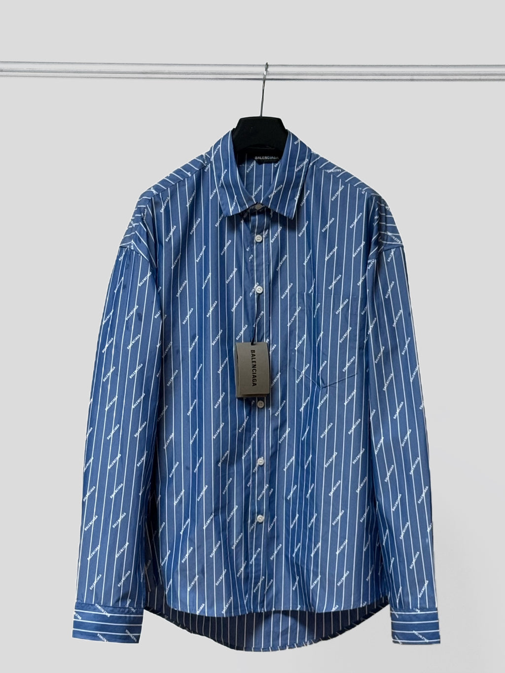 Blue button-up shirt, long sleeves, vertical pinstripe logo print