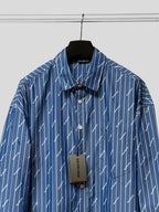 Blue button-up shirt with pointed collar, button placket, and hanging size tag