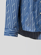 Blue button-up shirt hem with vertical pinstripe logo print and striped cuff