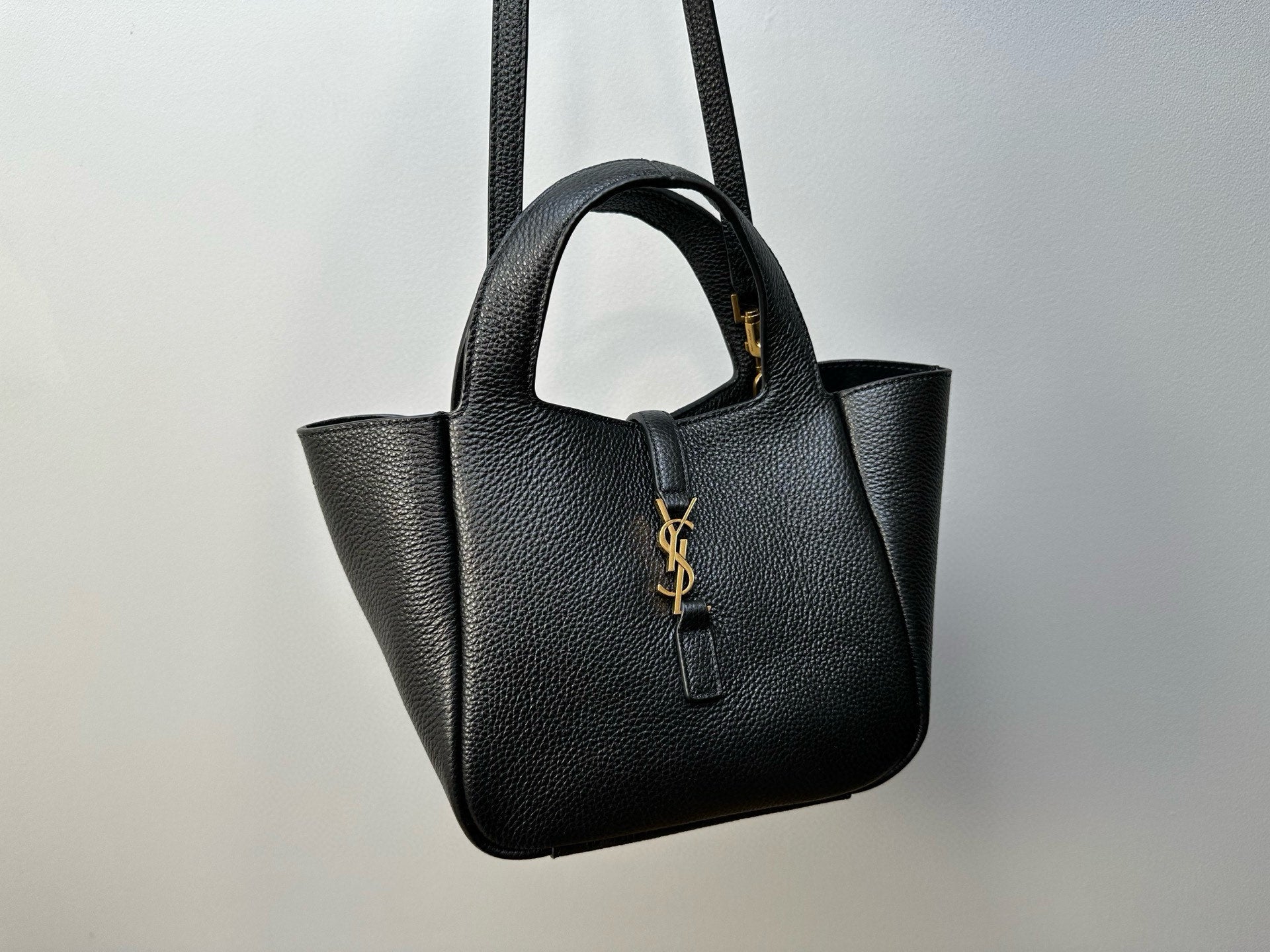 YSL tote bag front view with top handles, structured silhouette, and gold-tone logo charm