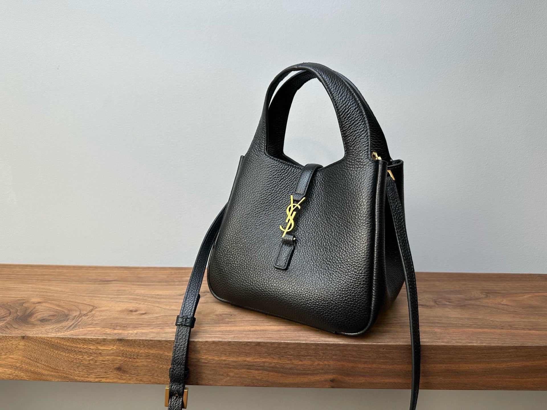 Black leather mini handbag front view with top handle, YSL logo and strap
