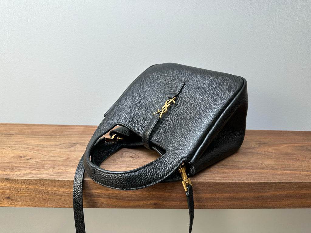 Black leather mini handbag side view with YSL logo plaque and strap hardware