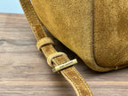 Gold suede strap with SAINT LAURENT label on tan mini tote bag strap