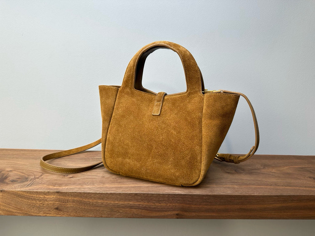 Tan suede tote bag with top handles and crossbody strap, structured shape