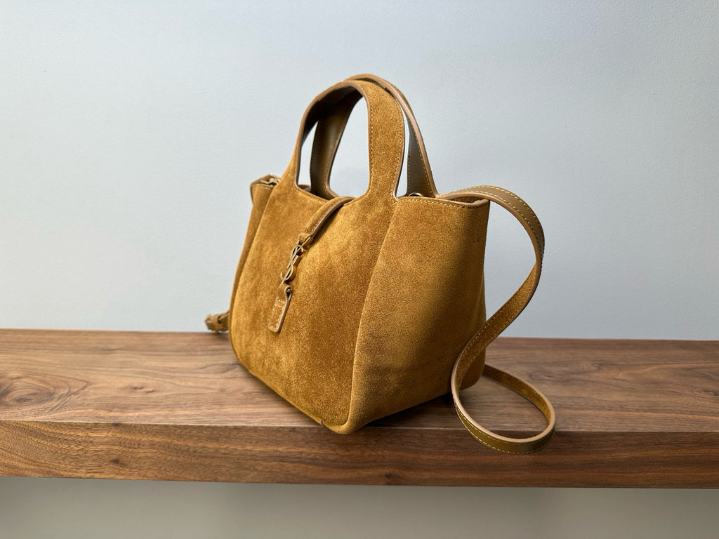 Tan suede tote bag with top handle and shoulder strap, front zip pocket detail