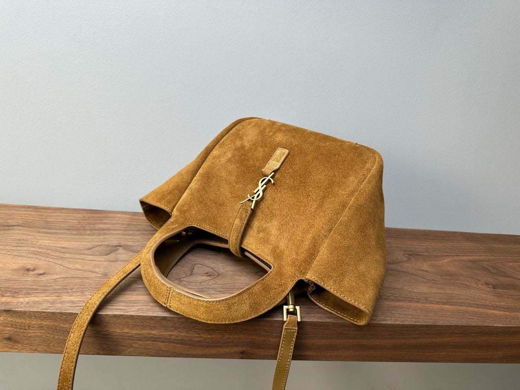 Tan suede tote bag with top flap, visible opening, and gold-tone YSL charm