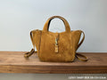 Tan suede tote bag with top handles, gold-tone YSL emblem, and zipper pull
