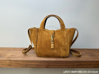 Tan suede tote bag with top handles, gold-tone YSL emblem, and zipper pull