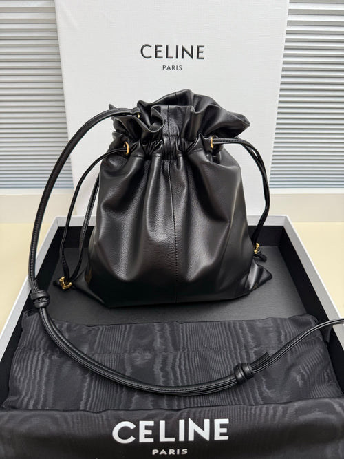Black leather drawstring bag with gold-toned logo and adjustable shoulder strap