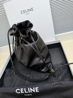 Black leather crossbody drawstring bag with gold-toned clasp and shoulder strap