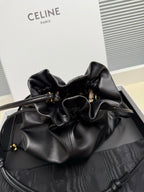 Black leather drawstring bag with gathered top and gold-toned eyelets