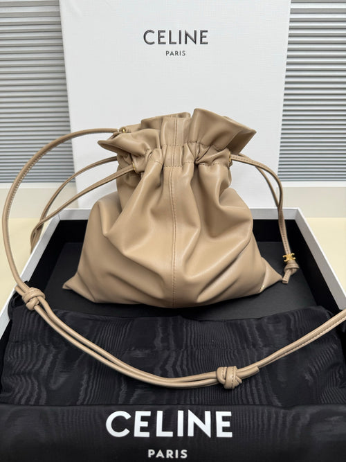 Beige leather drawstring pouch bag with gathered top and braided cord handles
